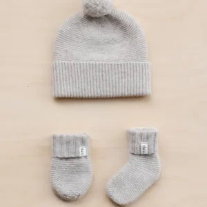TBCo Merino Wool Baby Accessories Bundle in oatmeal melange featuring knitted beanie with pom-pom, cosy mittens and socks