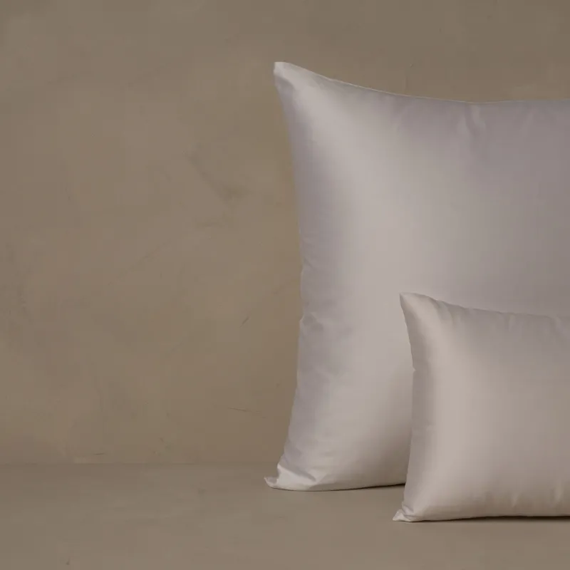 A small boudoir or travel size pillow stacked in front of a large euro size pillow. The pillow cases are made of LETTO's warm and buttery Classic Cotton Sateen in color white.