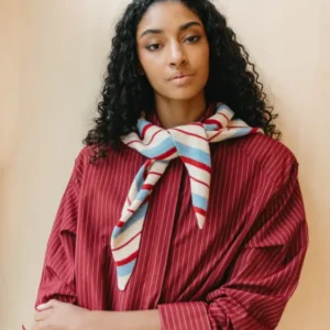 Model wearing TBCo Merino Wool Triangle Scarf in Blue & Red Stripe, tied loosely over red pinstripe shirt