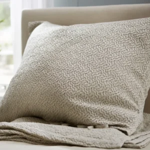 SDH Allegro platinum jacquard pillow sham with textured woven pattern on bed.