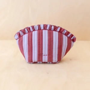 TBCo Cotton Wash Bag in Lilac Stripe, quilted with muted red and pale pink stripes, ruffled top trim, displayed on a light wood surface, showcasing its playful shape.