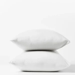 Coyuchi Crinkled Percale pillowcase pair in white, two pillows stacked against white background.