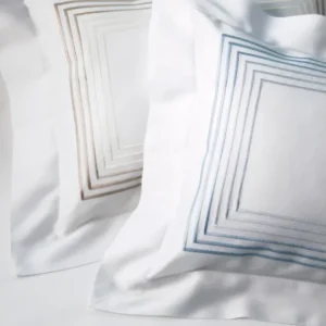 Dea Milano white pillowcases with concentric square embroidery in taupe and blue.