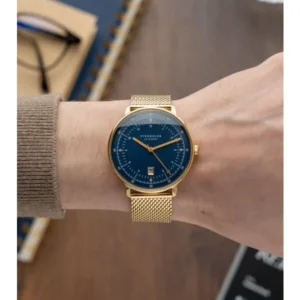 Herrenarmbanduhr am Handgelenk mit blauem Zifferblatt und goldfarbenem Meshband