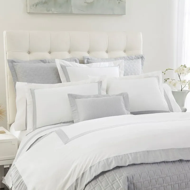 Home Treasures Terra quilted white coverlet and silver euro sham set on styled bed.